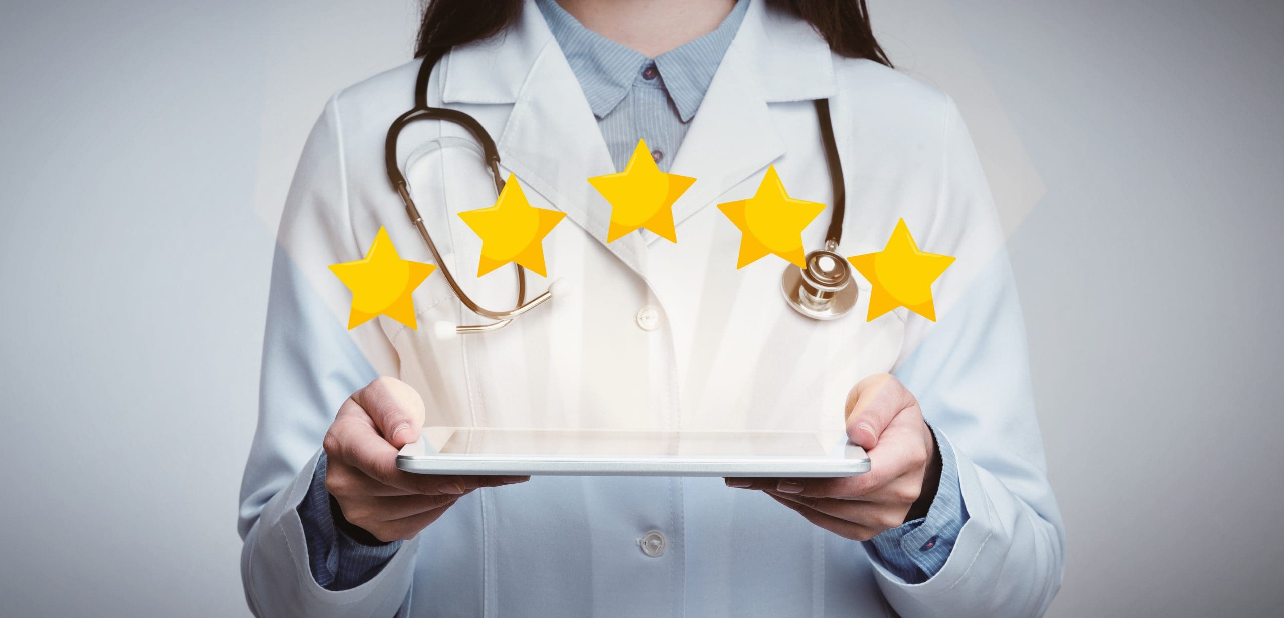 A female doctor holding a tablet with stars on it.