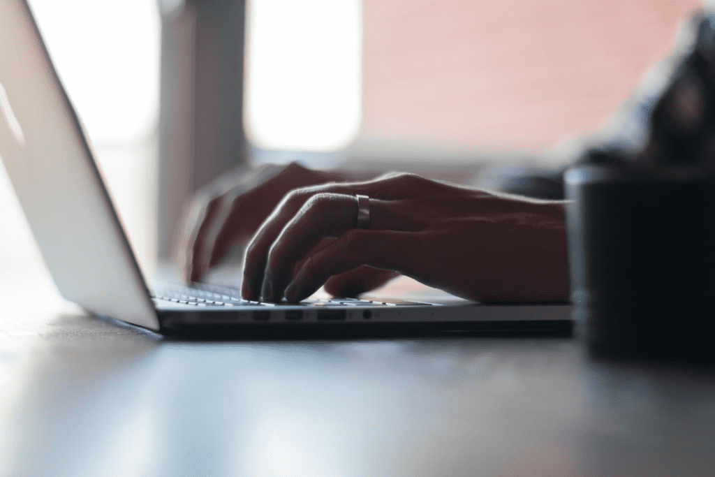 a person typing on a laptop on a table.