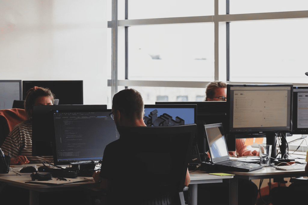 a group of people working on computers in a room.